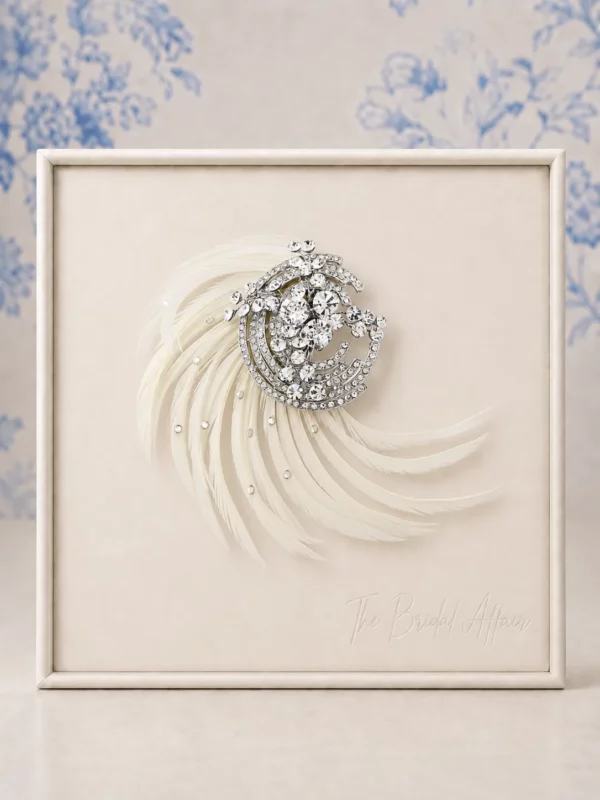 Athena 3583 Ivory feather and crystal bridal hair accessory displayed on The Bridal Affair ivory satin product frame with soft blue willow background.