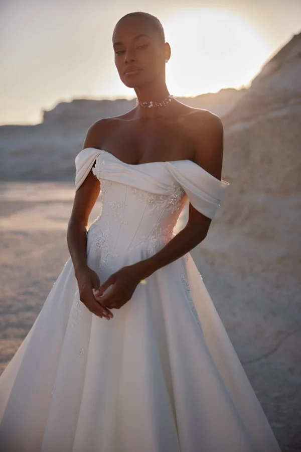 Close-up of Eva Lendel Chabli wedding gown showing draped off-shoulder neckline and embroidered corset details