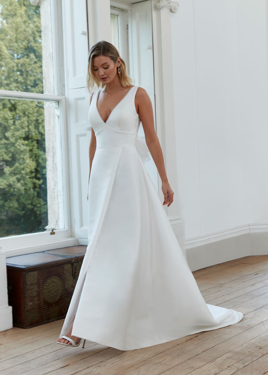 Romantica of Devon Dawn bridal gown front view featuring deep V-neckline and clean satin A-line silhouette in ivory