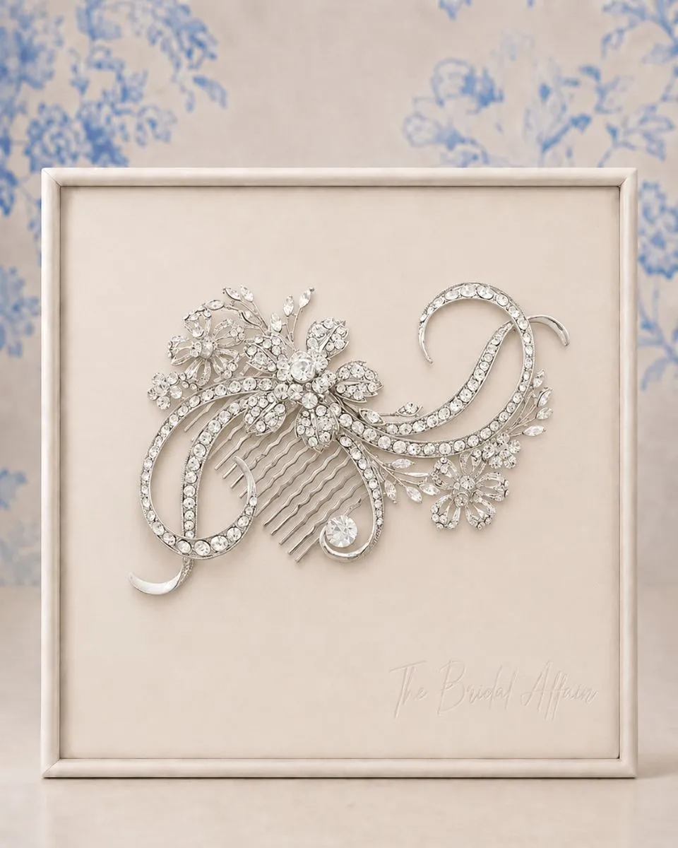Athena 4038 Bejewelled Starlet Comb displayed on The Bridal Affair ivory satin frame with soft blue willow background.
