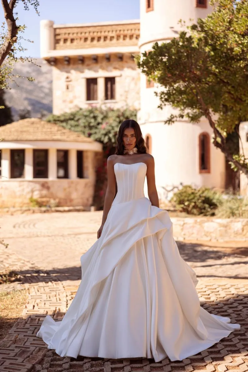 Cosmobella 8290 by Demetrios ivory strapless wedding dress with sculpted bodice and dramatic draped ballgown skirt
