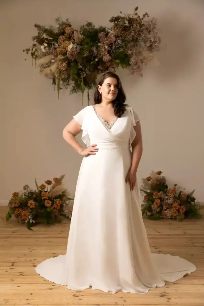 Curvy bride wearing a soft tulle A-line wedding dress with pleated bodice
