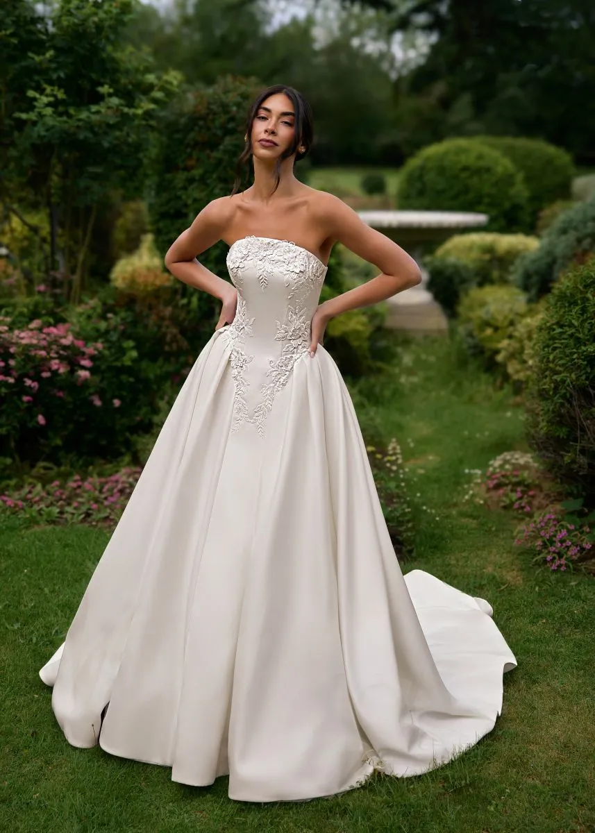 Eira by Phoenix Gowns strapless satin ballgown wedding dress with floral lace bodice and full flowing skirt.