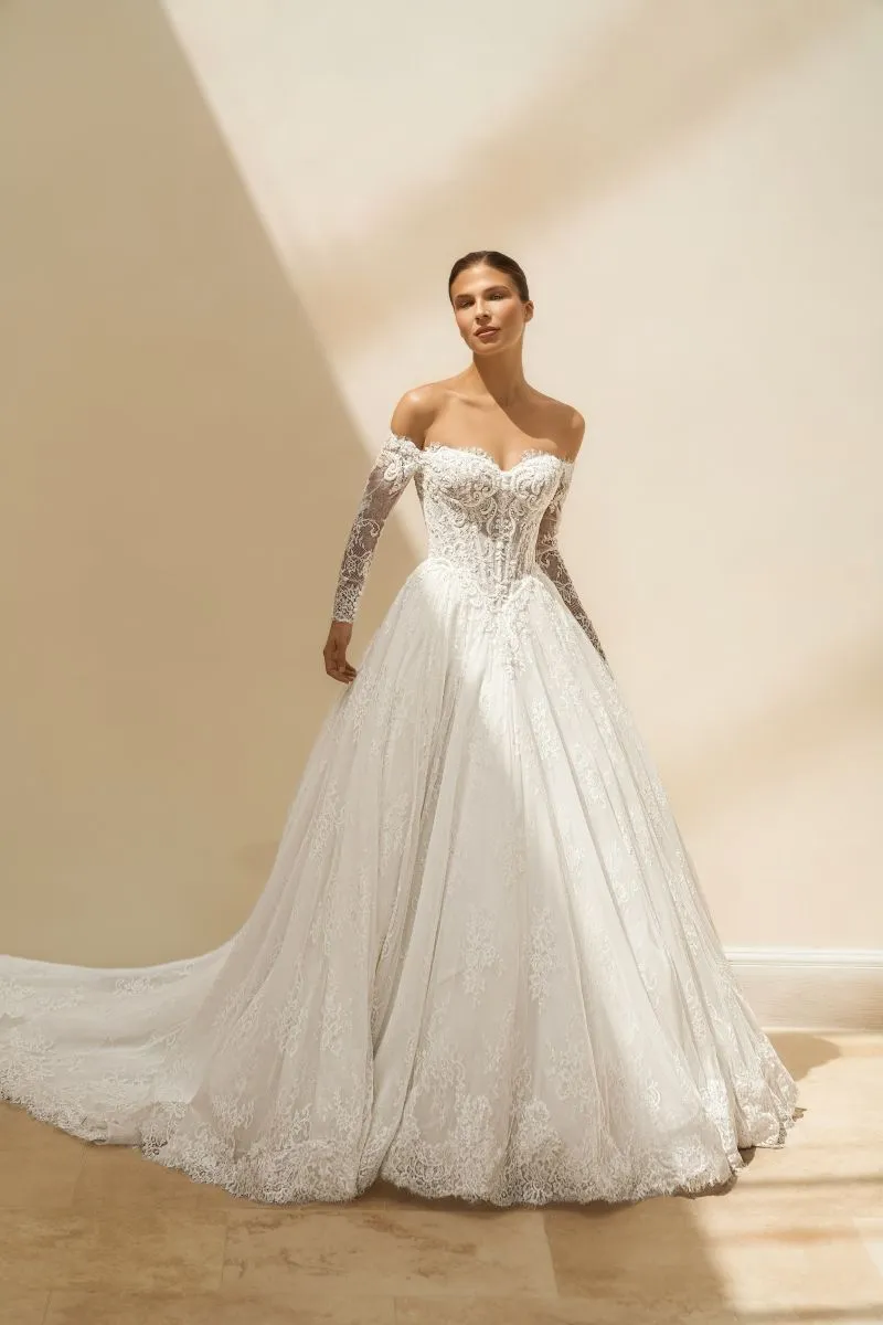 Eliska by Danielle Couture ivory off-the-shoulder lace ballgown wedding dress with sweetheart neckline, long illusion sleeves and full skirt.