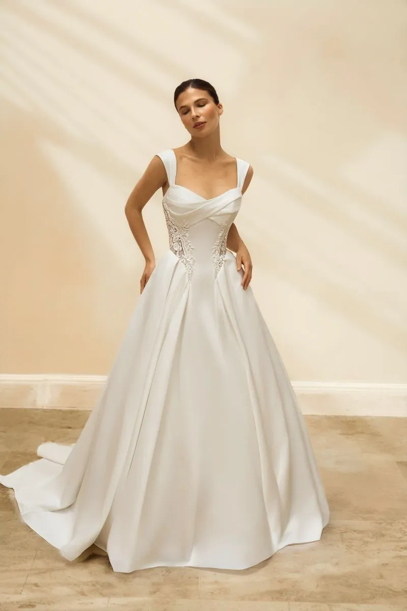 Evelina by Danielle Couture ivory satin A-line wedding dress with draped sweetheart neckline, wide shoulder straps, sculpted waist and floral lace side panels.